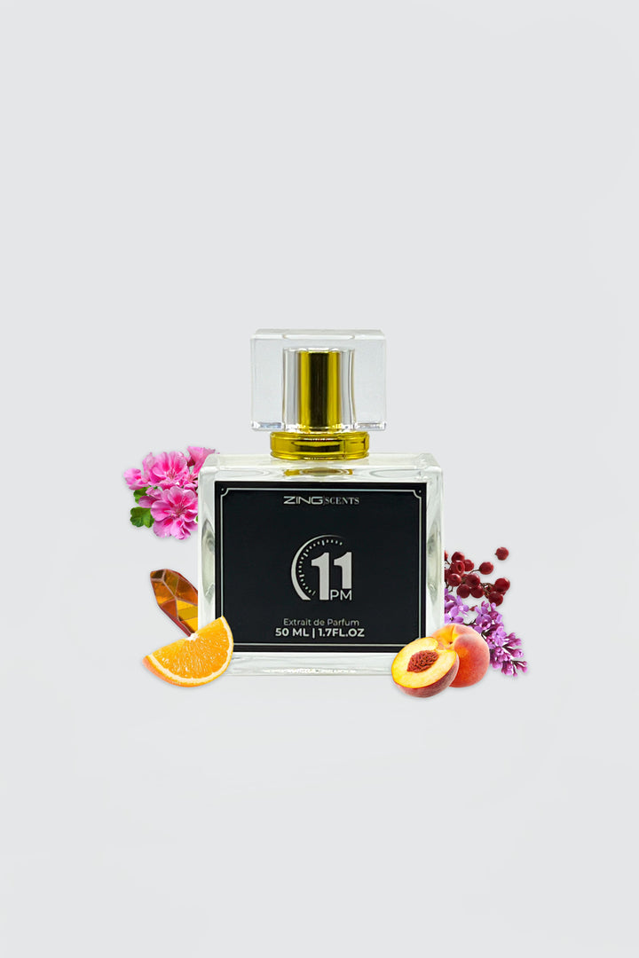 11 pm perfume bottle with flowers, citrus and other scent associated ingredients on sides of bottle