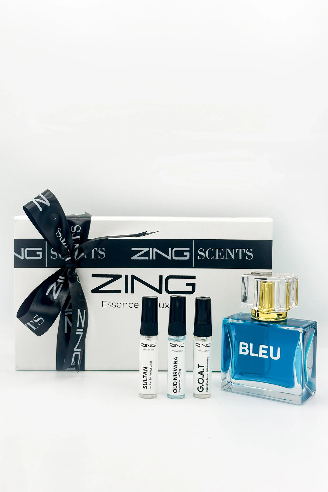 White ZING Scents gift box with black ribbon, featuring  BLEU perfume bottle and three tester bottles of Sultan, Oud Nirvana, and G.O.A.T