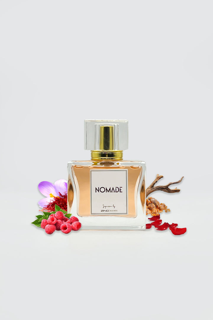 nomade perfume bottle shown with berries, woods and other scent related elements