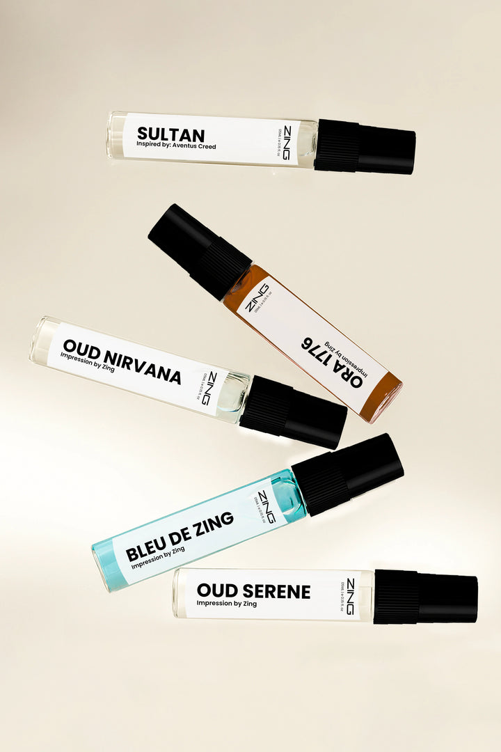 ZING discovery set featuring travel spray bottles of Sultan inspired by Aventus Creed, Oud Nirvana, Ora 1776, Bleu de Zing, and Oud Serene arranged on a neutral background