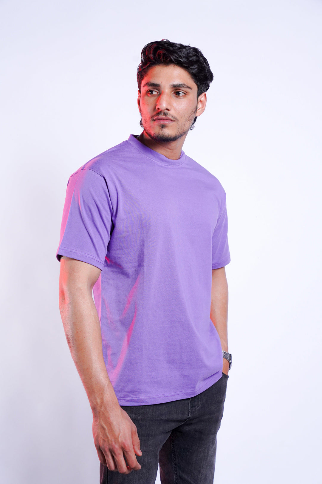 male model wearing a lavender t-shirt standing against a white background
